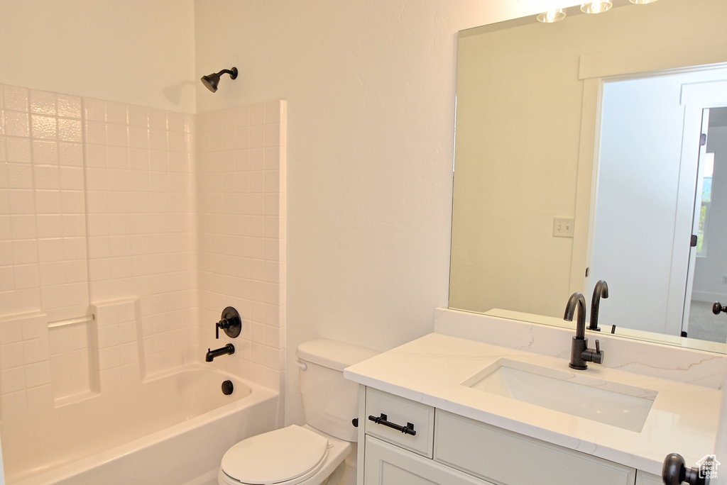 Bathroom featuring toilet, shower / bathtub combination, and vanity