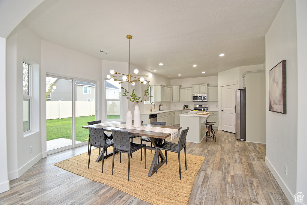 Dining space with light wood-style floors, recessed lighting, a notable chandelier, and baseboards