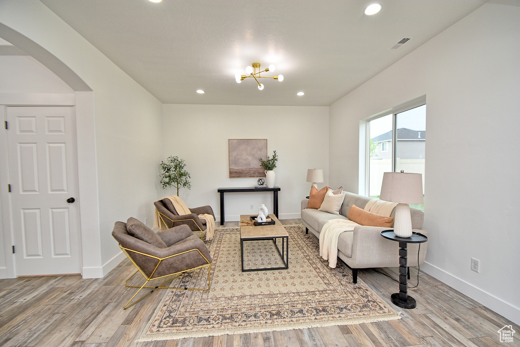 Living area with visible vents, baseboards, arched walkways, recessed lighting, and wood finished floors