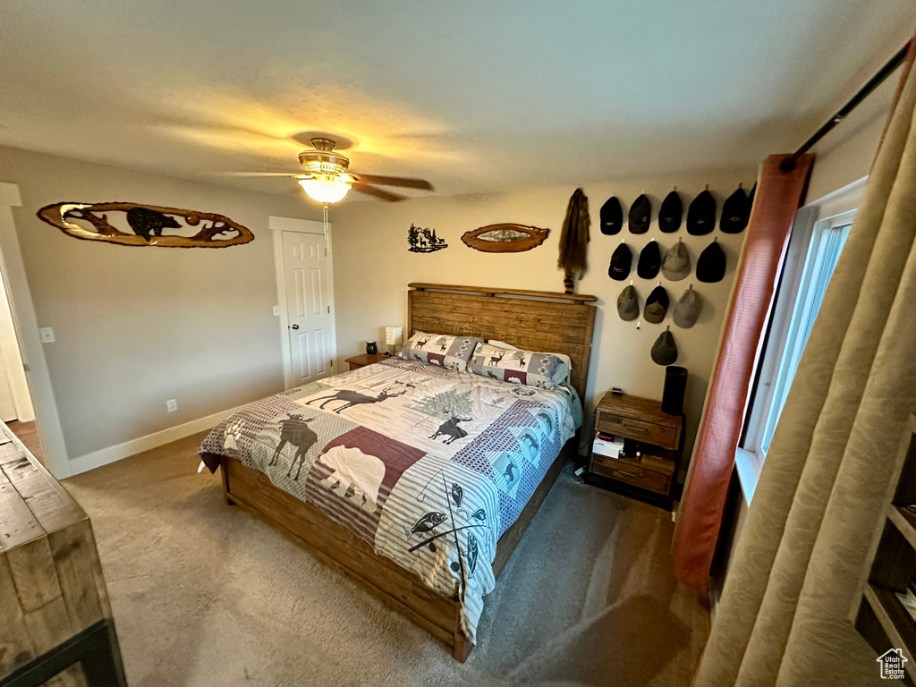 Bedroom with ceiling fan, baseboards, and carpet floors