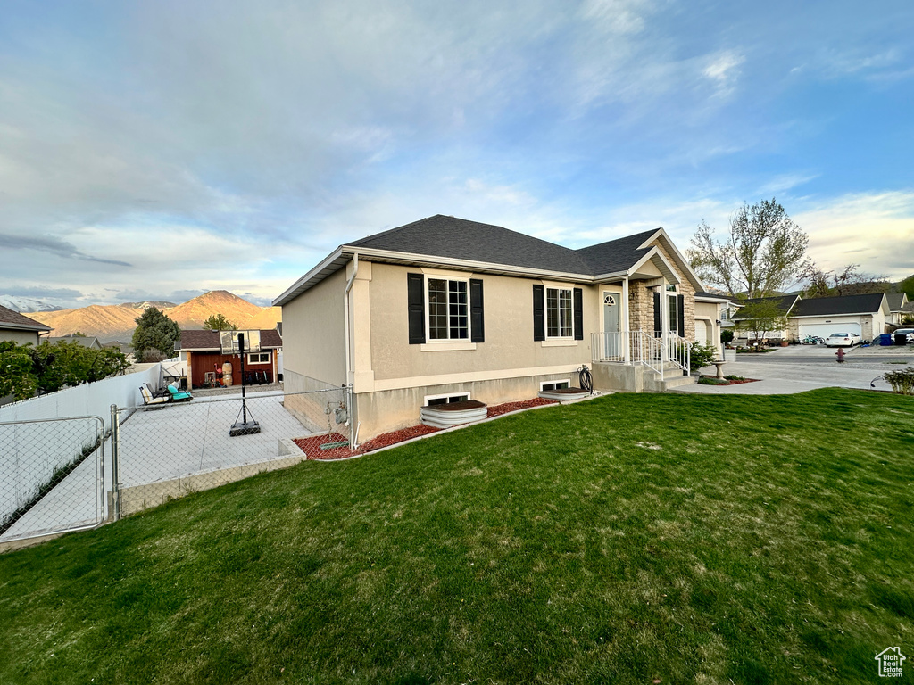 Single story home with a front yard, a mountain view, a gate, and fence