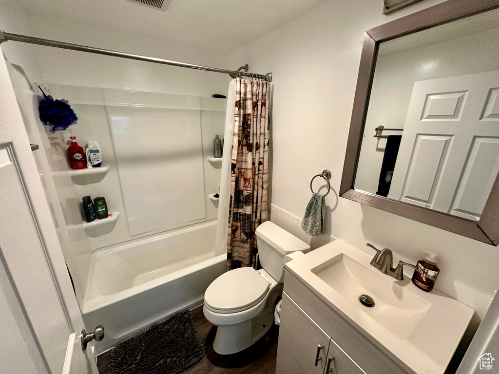 Full bathroom featuring shower / bathtub combination with curtain, vanity, and toilet