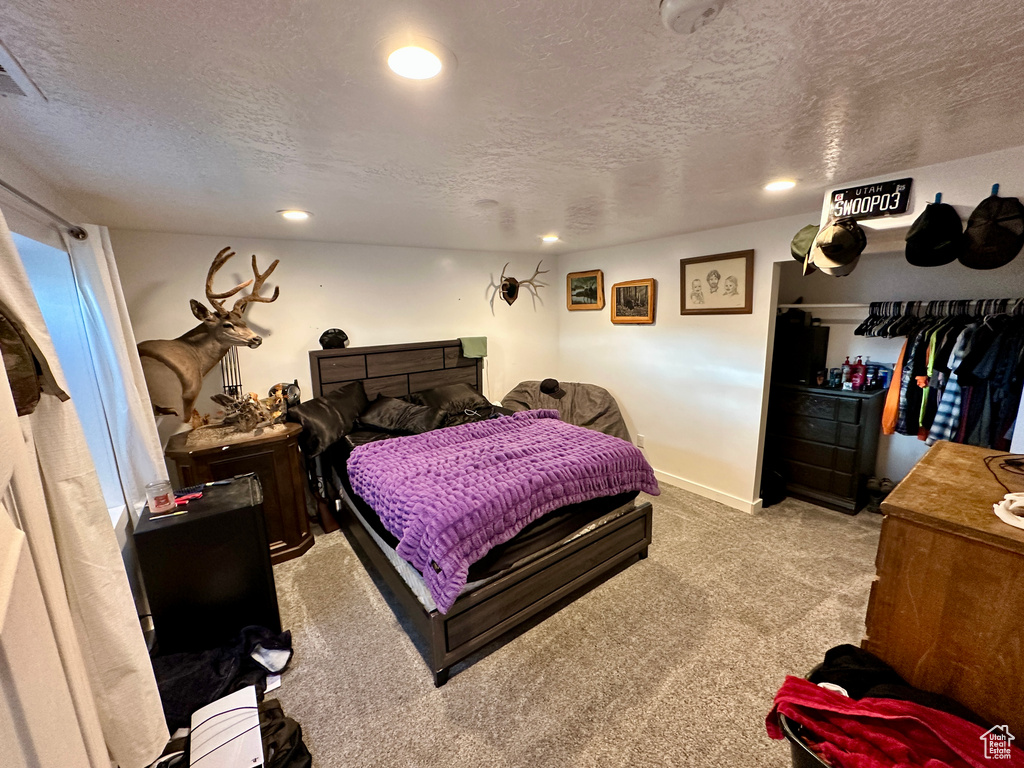 Carpeted bedroom with a textured ceiling, recessed lighting, and baseboards