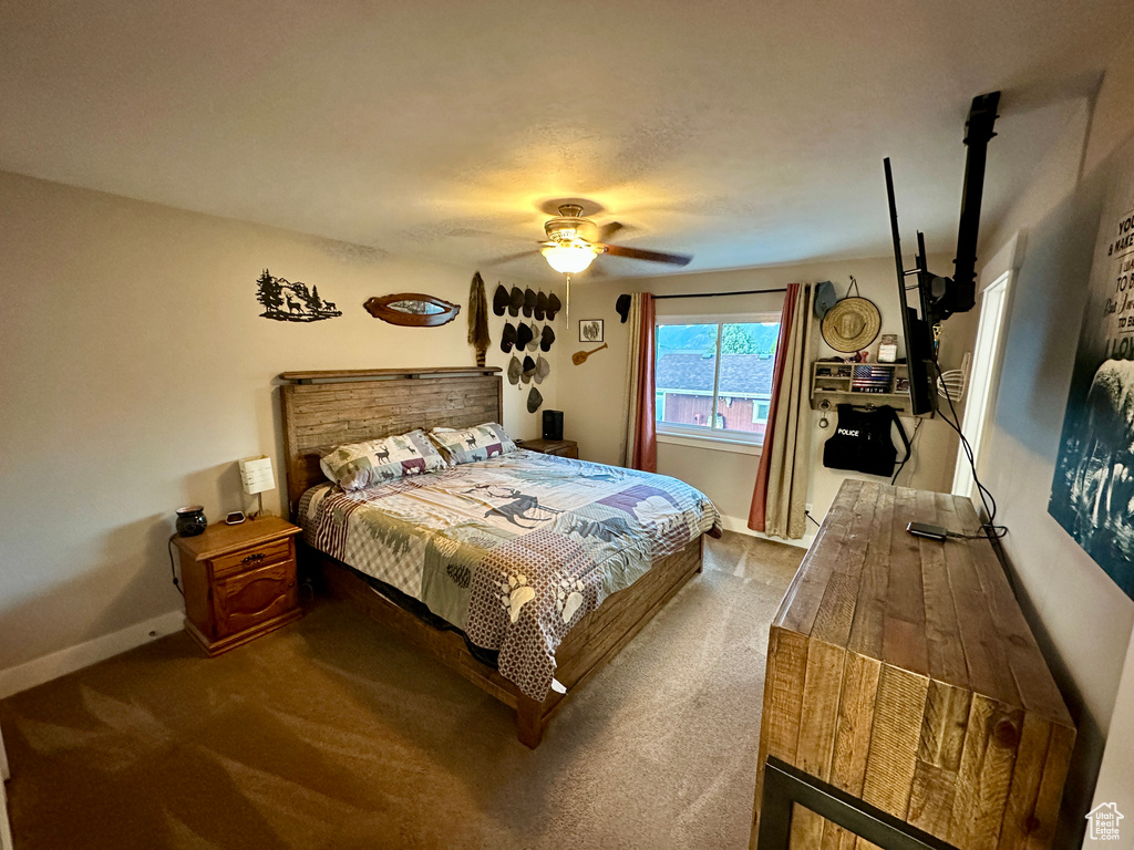 Carpeted bedroom with baseboards and a ceiling fan