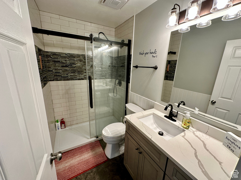 Full bath with toilet, visible vents, a shower stall, and vanity
