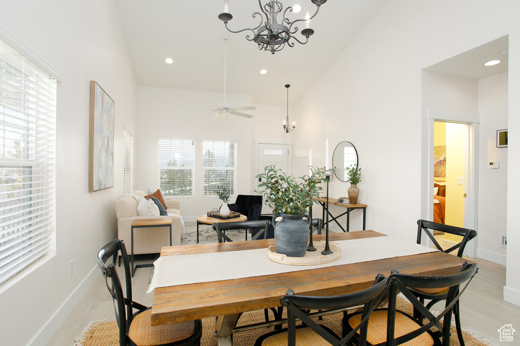Dining space featuring high vaulted ceiling, a wealth of natural light, light wood-style floors, and baseboards