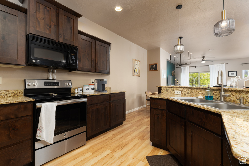Kitchen featuring black microwave, dark brown cabinets, a sink, stainless steel range with electric stovetop, and light wood-style flooring