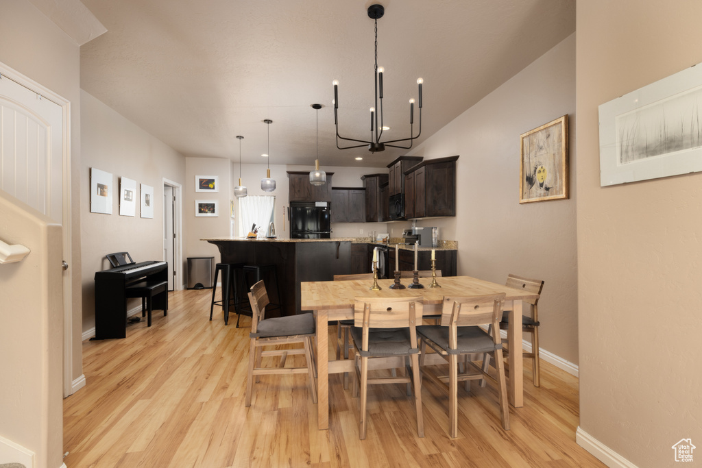 Dining room featuring an inviting chandelier, light wood-style flooring, and baseboards