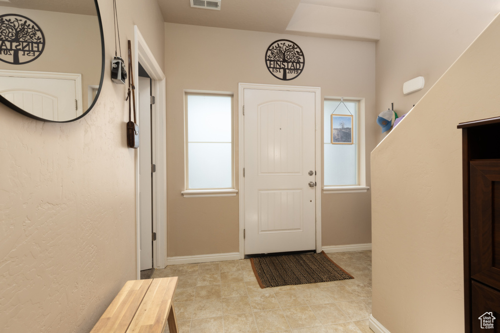 Foyer with visible vents, baseboards, and light tile patterned flooring