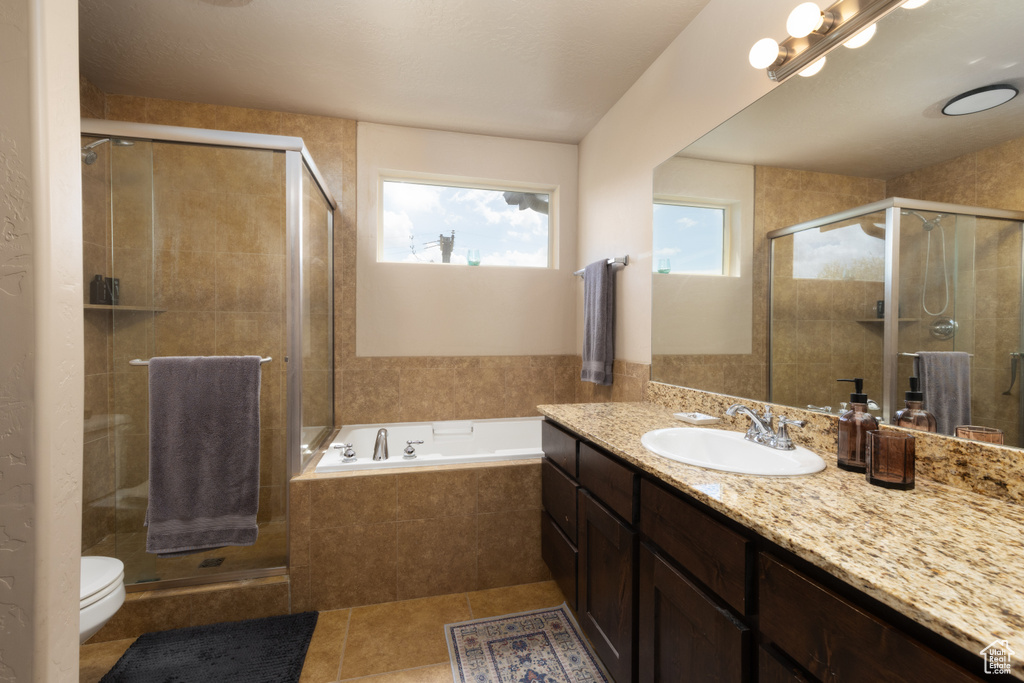 Full bath with vanity, toilet, tile patterned floors, a shower stall, and a bath