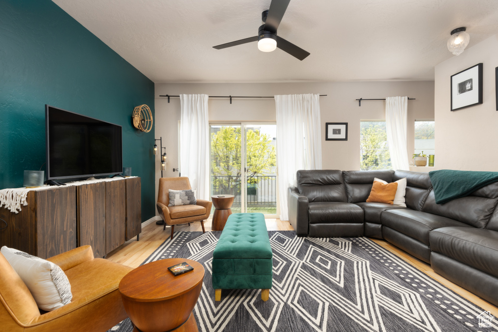 Living area with a ceiling fan, plenty of natural light, and light wood-style floors