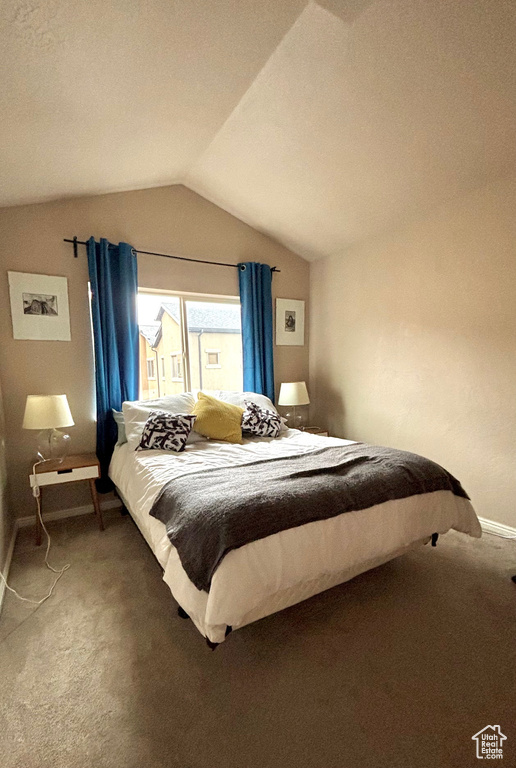 Bedroom with lofted ceiling, baseboards, and carpet floors