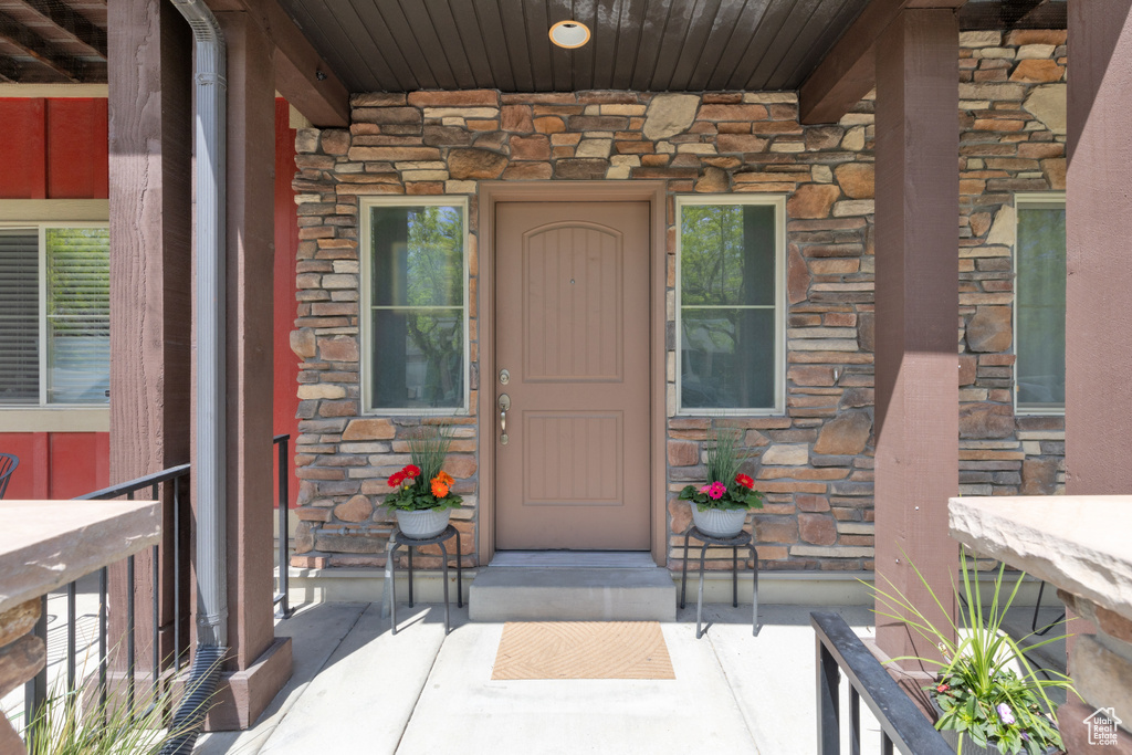 Doorway to property featuring a porch and stone siding