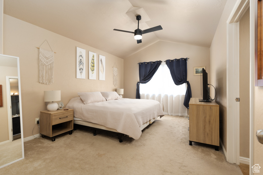 Bedroom featuring baseboards, ceiling fan, vaulted ceiling, and light colored carpet