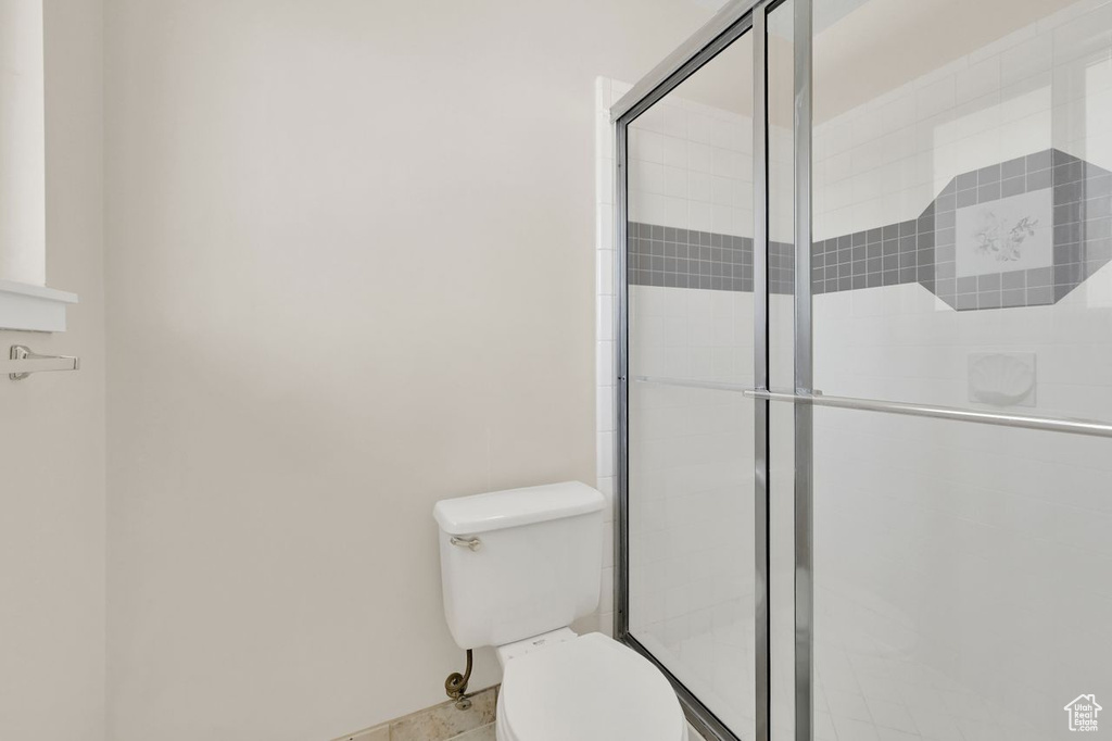 Full bath with toilet and a stall shower