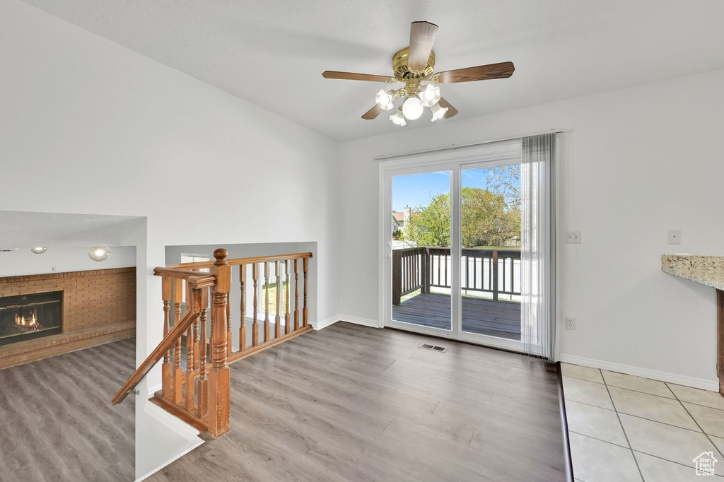 Interior space with a glass covered fireplace, wood finished floors, and baseboards
