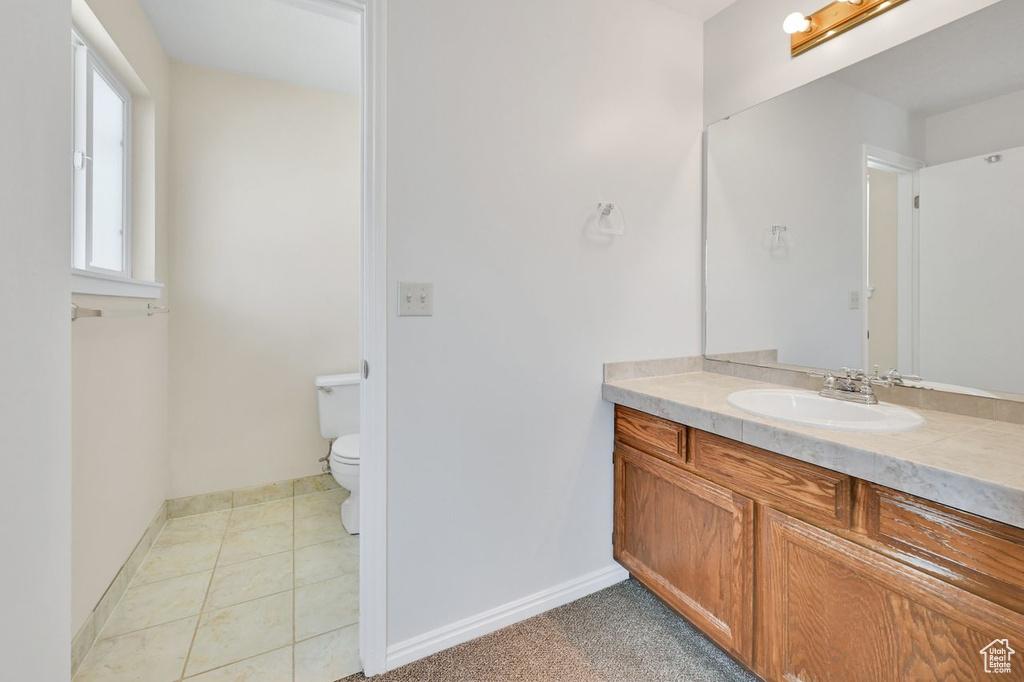 Bathroom with vanity, toilet, and baseboards