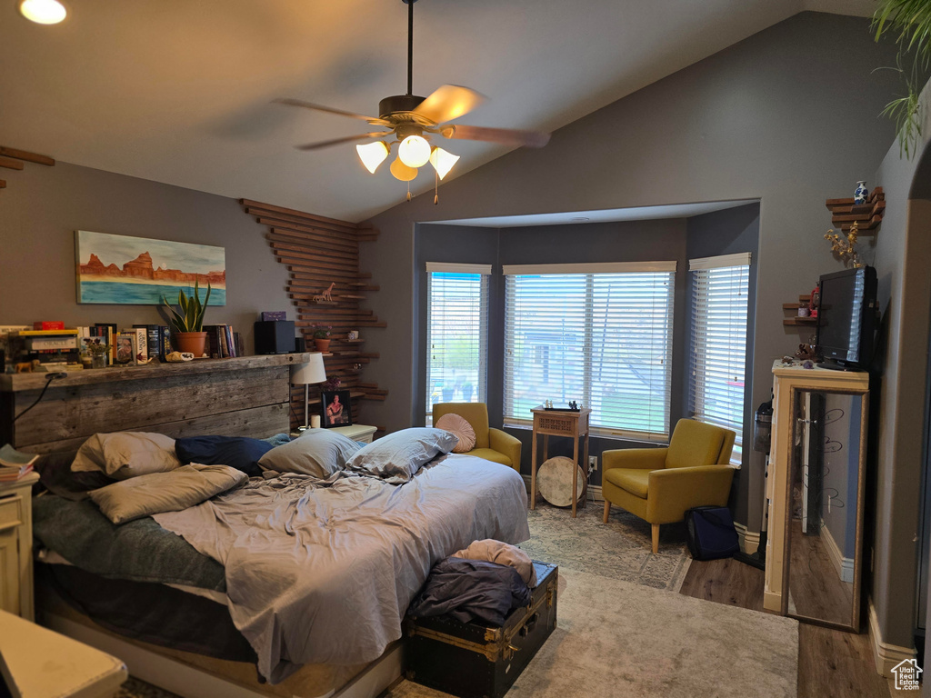 Bedroom featuring wood finished floors, a ceiling fan, and lofted ceiling