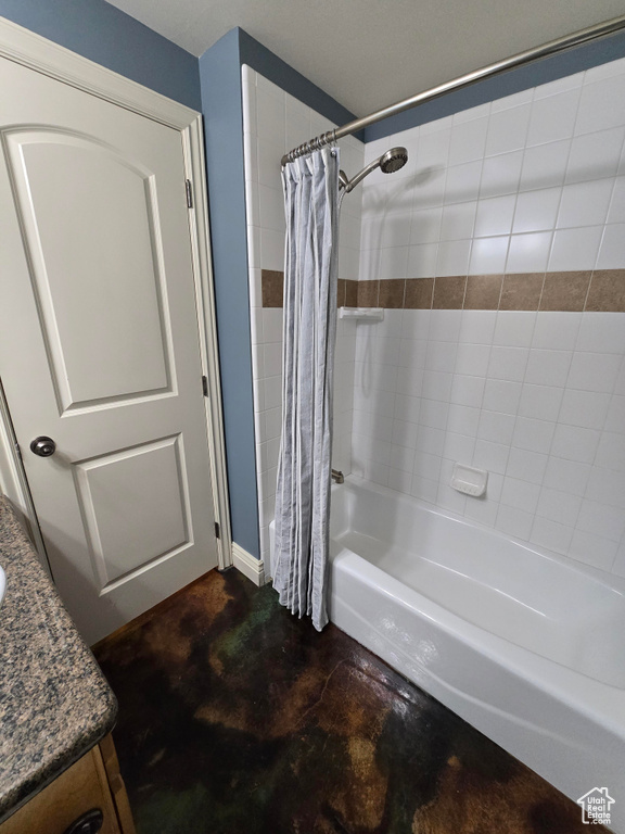 Full bathroom with shower / bath combo with shower curtain, finished concrete flooring, and vanity