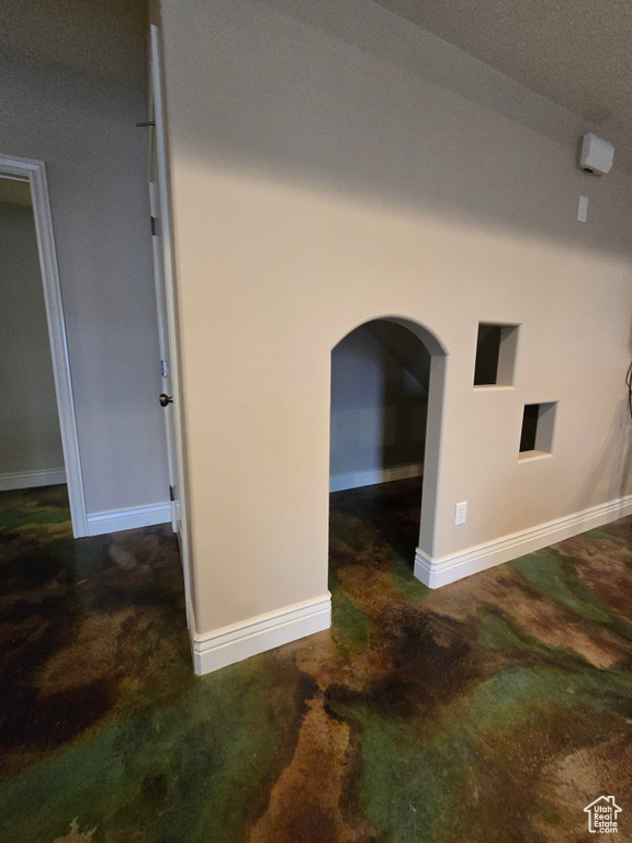 Interior details with concrete floors, baseboards, and arched walkways