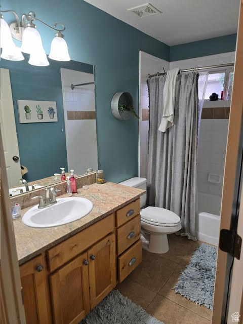 Bathroom with shower / tub combo, visible vents, toilet, vanity, and tile patterned flooring