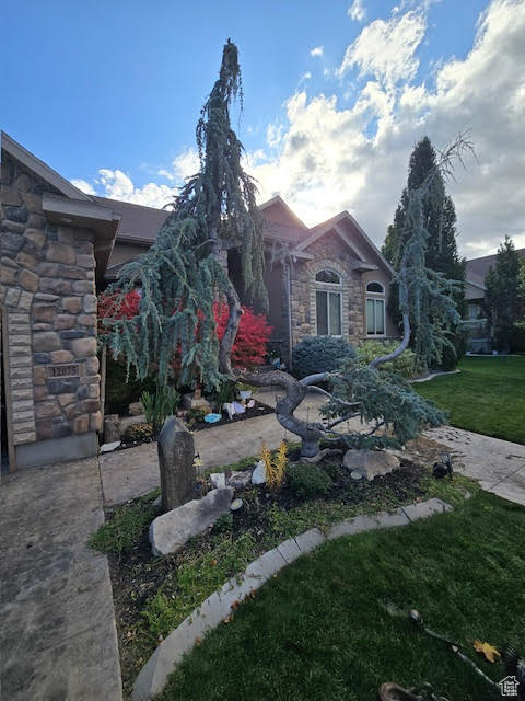 Exterior space featuring a front yard and stone siding