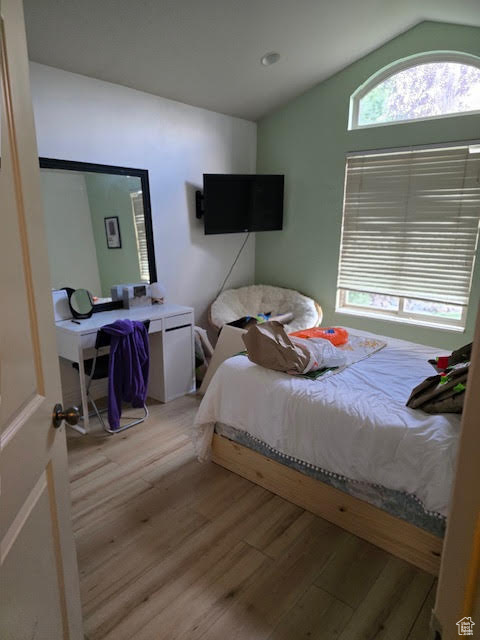 Bedroom featuring lofted ceiling and light wood-style floors