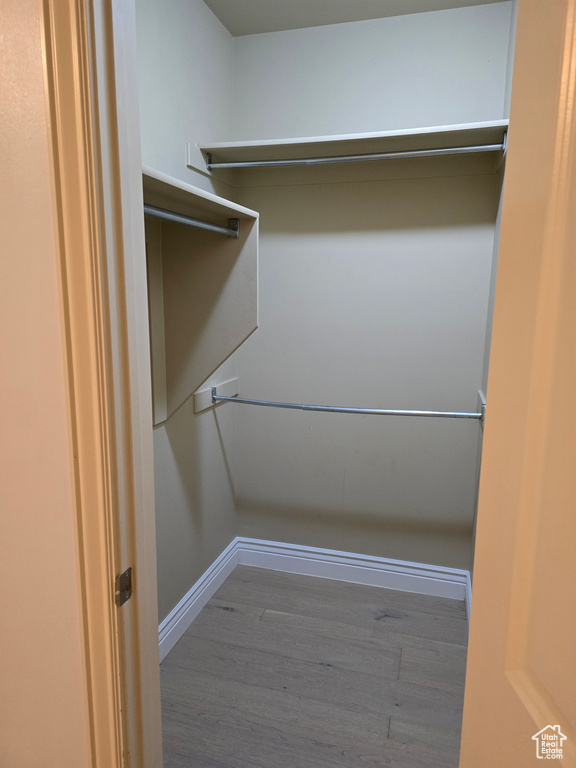Walk in closet with wood finished floors