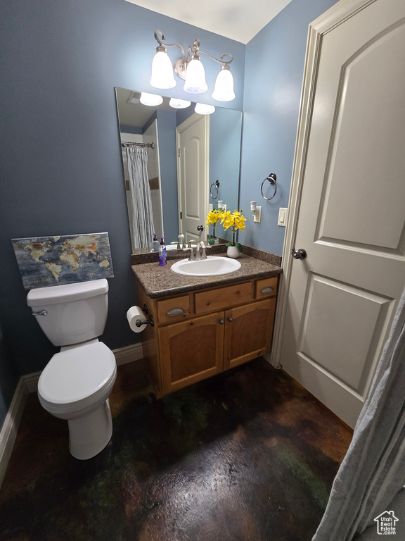 Bathroom with baseboards, toilet, concrete floors, and vanity
