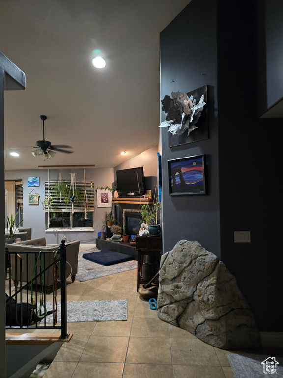 Living room featuring recessed lighting, tile patterned flooring, ceiling fan, and a glass covered fireplace