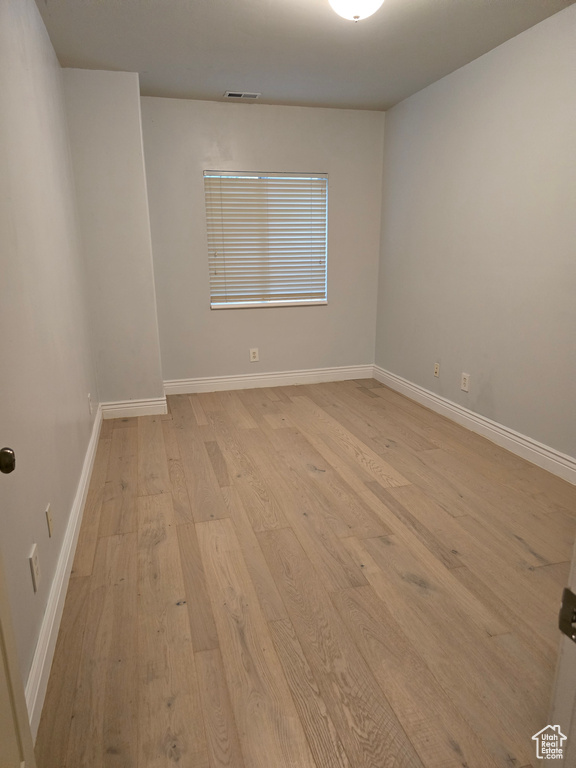 Empty room featuring baseboards, visible vents, and light wood-style flooring