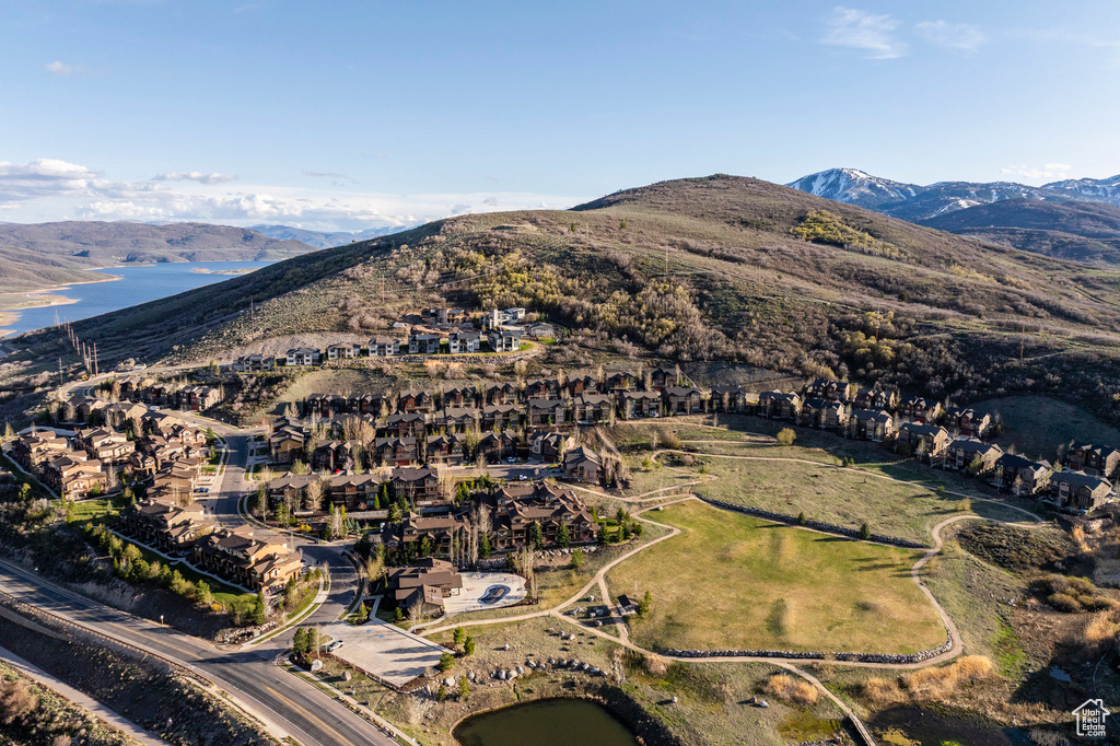 Aerial view of property and surrounding area with a water and mountain view and nearby suburban area
