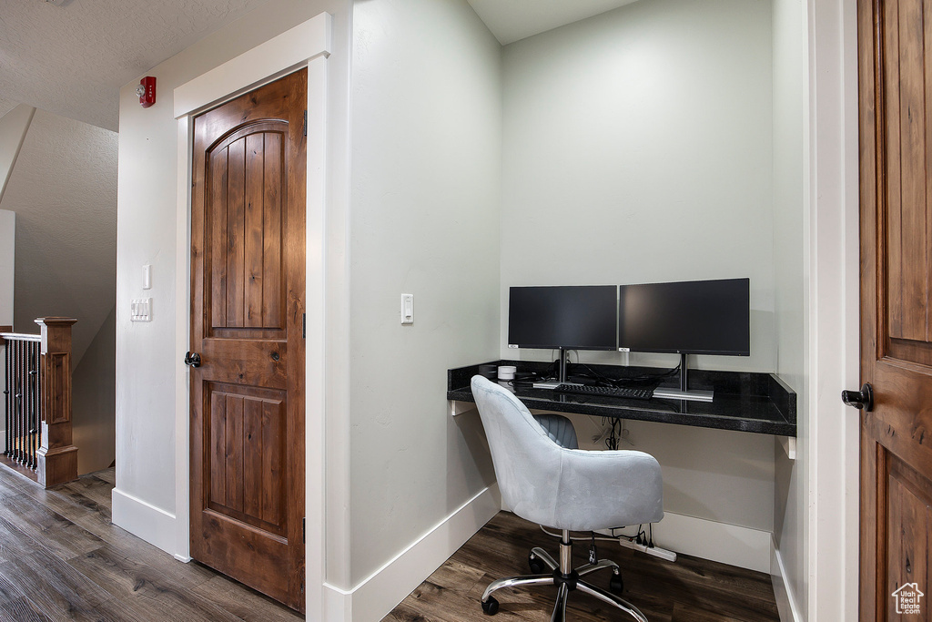 Office featuring dark wood-type flooring and baseboards