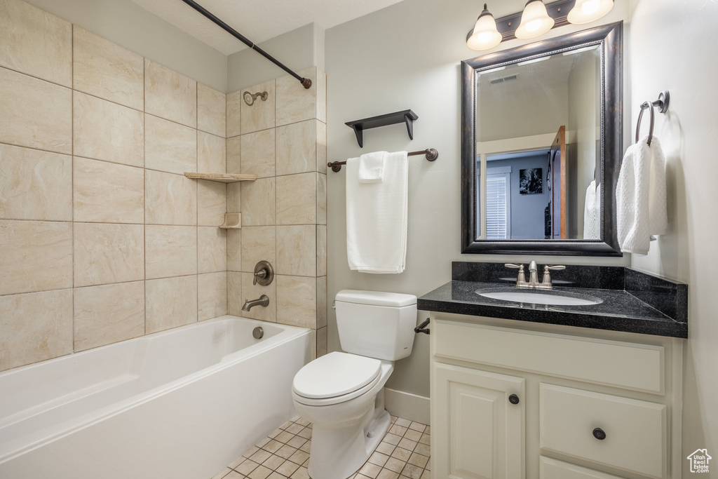 Bathroom featuring vanity, shower / bath combination, and tile patterned flooring