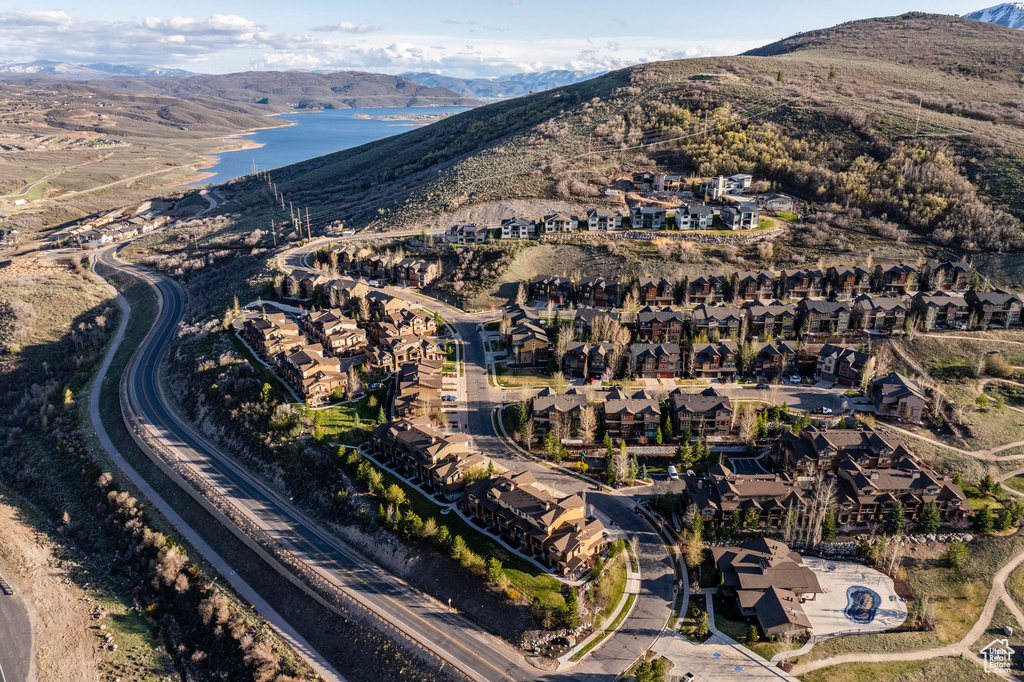 Aerial view of property and surrounding area featuring nearby suburban area and a water and mountain view