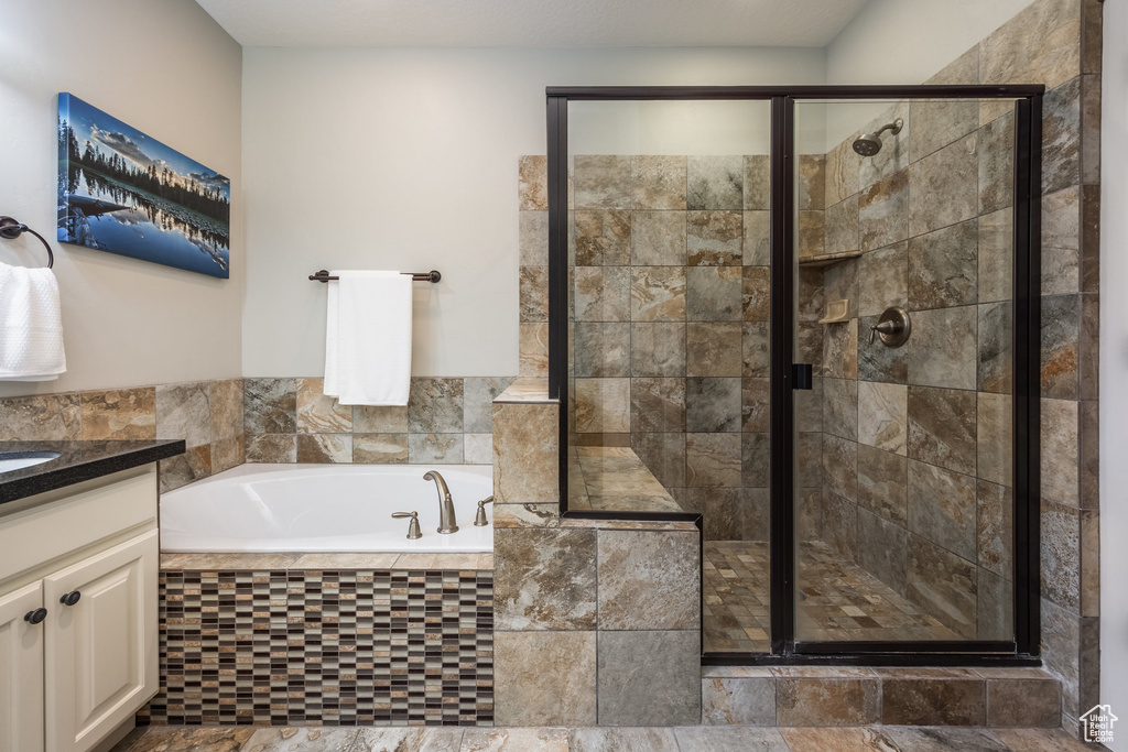 Bathroom featuring a garden tub, a stall shower, and vanity