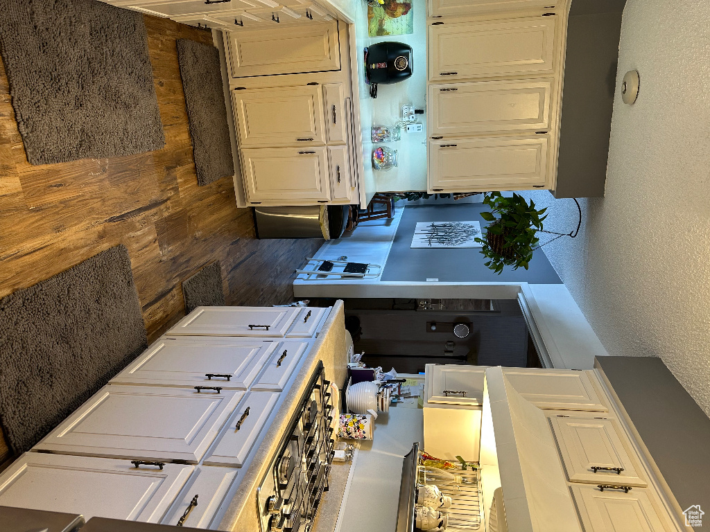 Kitchen with a textured wall and white cabinets