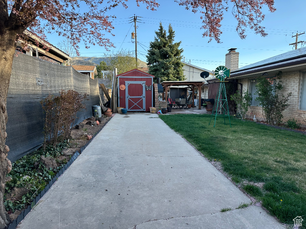 View of yard featuring a patio, a fenced backyard, a shed, and an outdoor structure