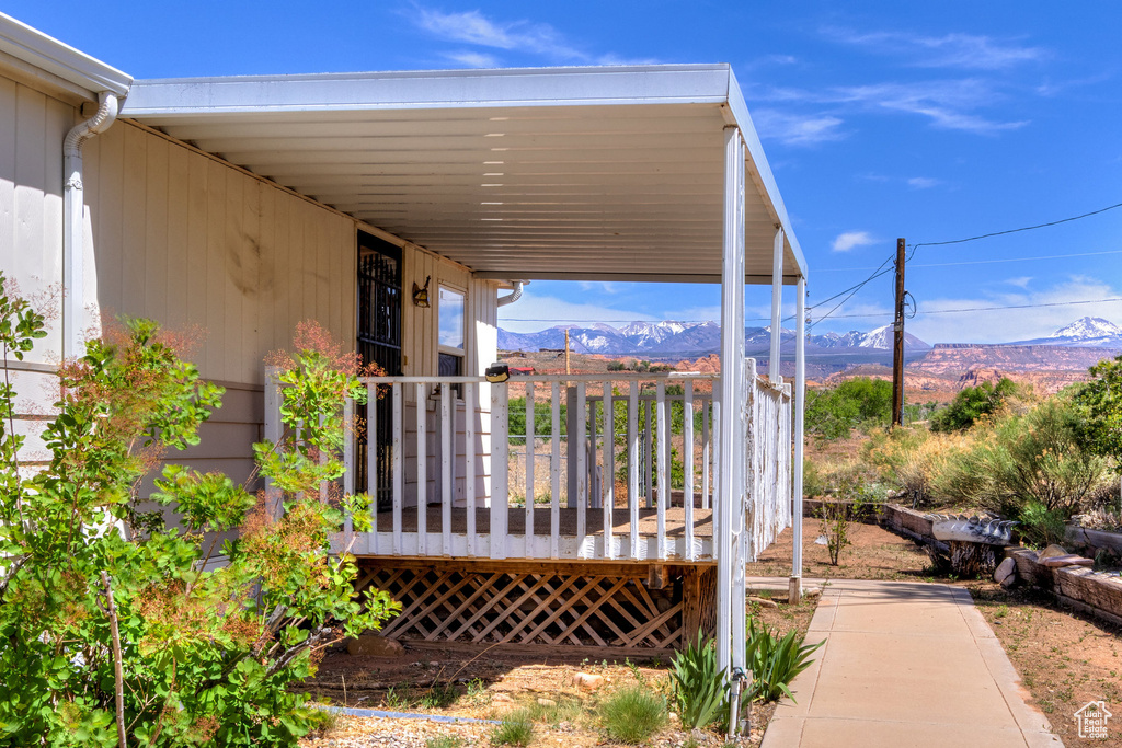 Wooden terrace featuring a mountain view and a carport