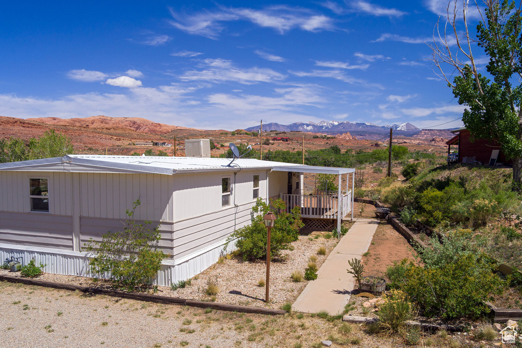 View of side of home with a mountain view and covered porch
