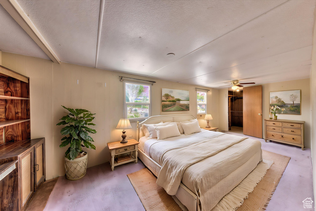 Bedroom featuring a ceiling fan and a textured ceiling