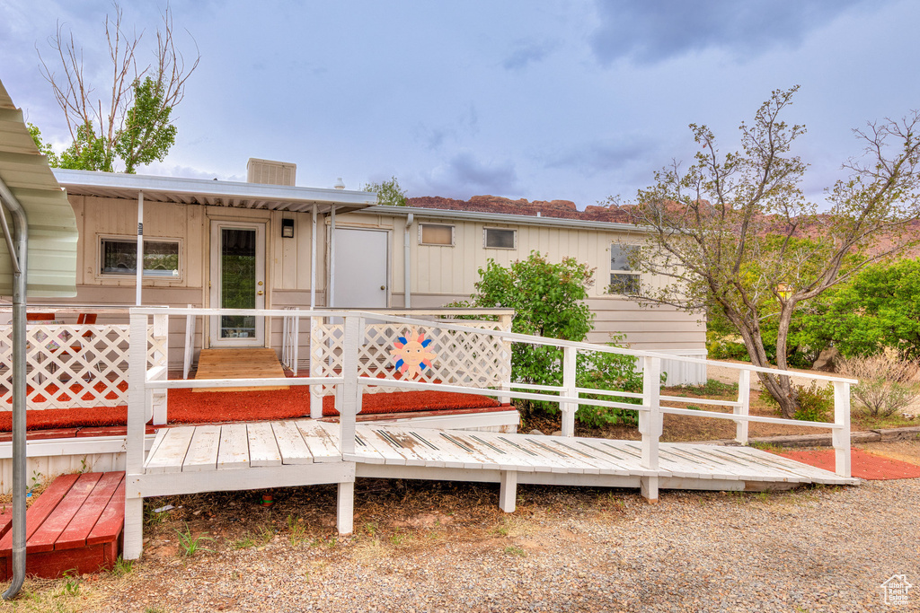 Rear view of house featuring board and batten siding and a deck