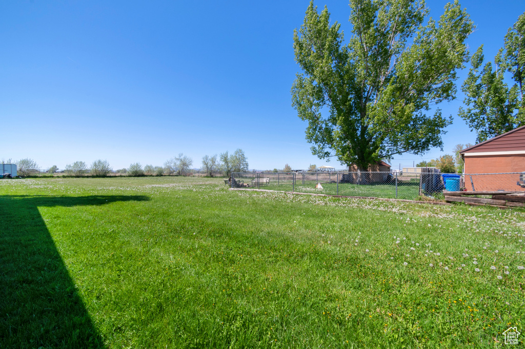 View of yard with a rural view and fence