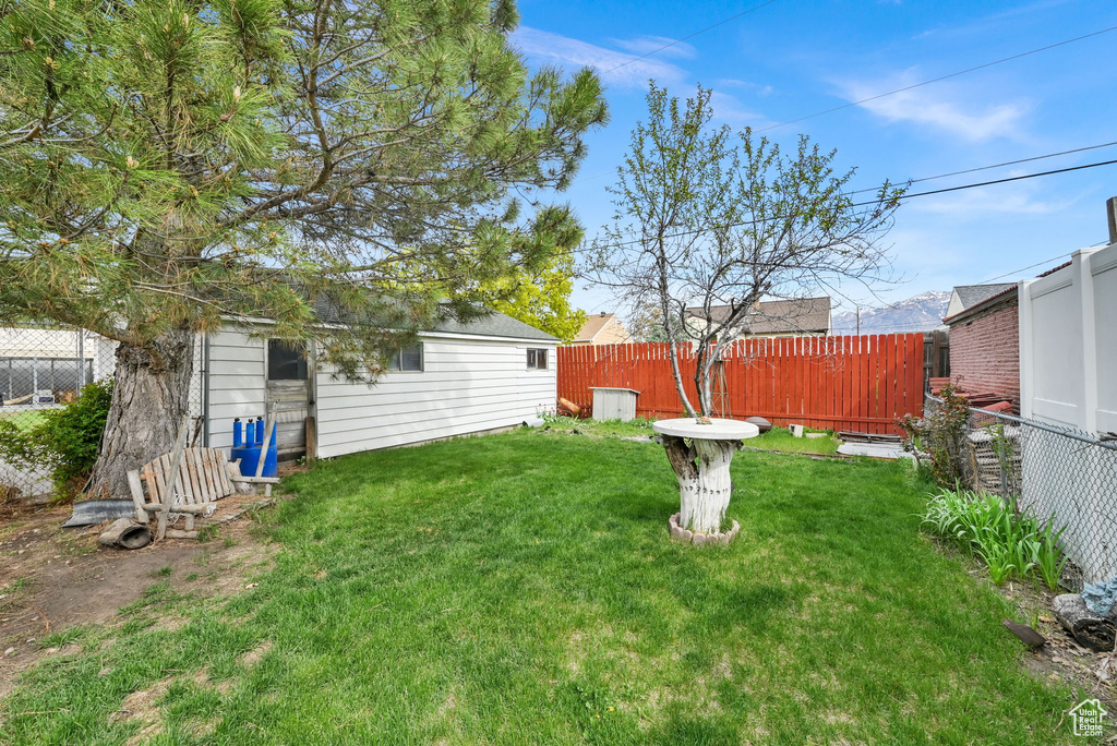 View of yard featuring fence and an outdoor structure