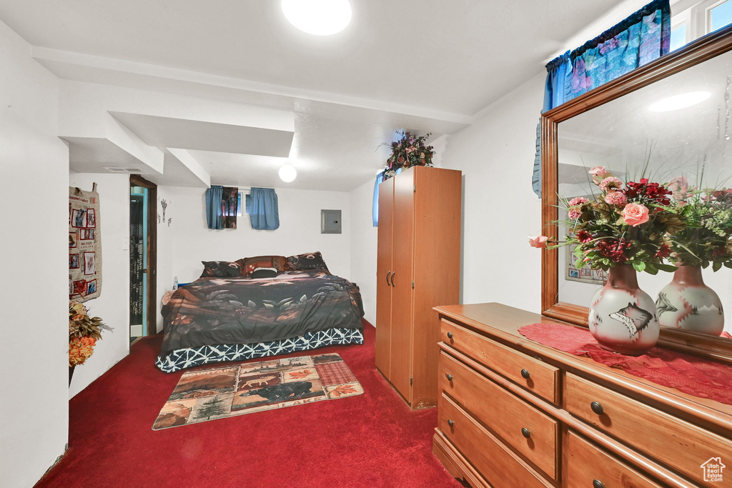 Bedroom featuring dark colored carpet and electric panel