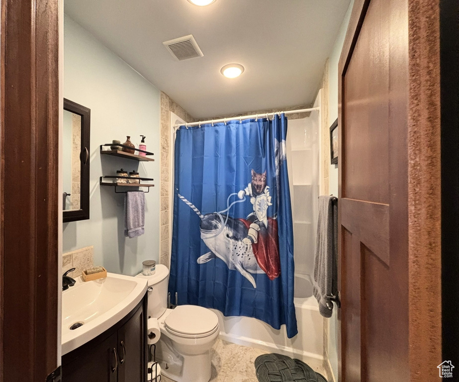Bathroom featuring visible vents, toilet, vanity, and shower / tub combo with curtain