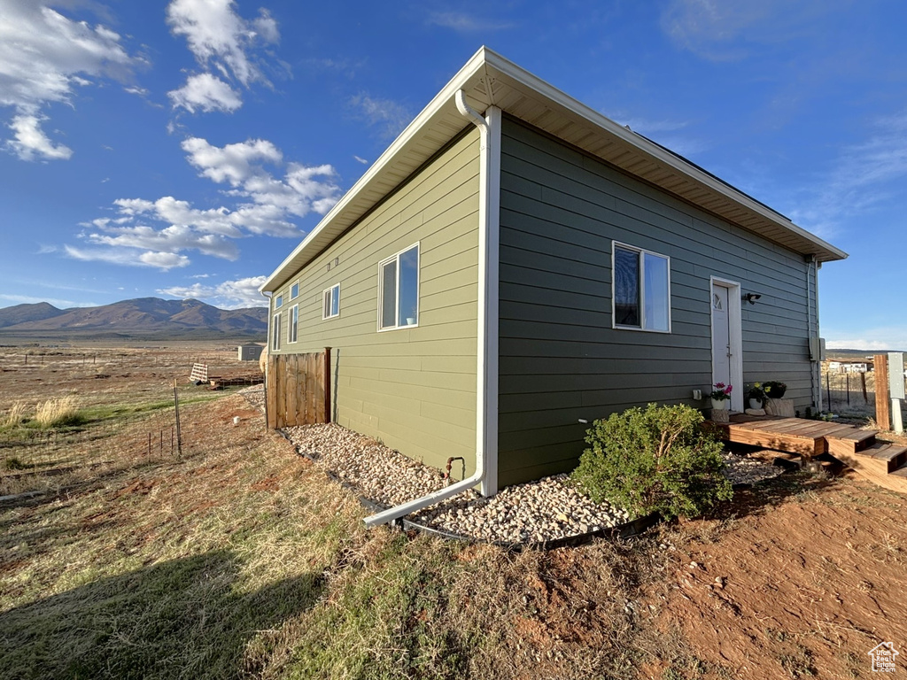 View of side of property with a deck with mountain view