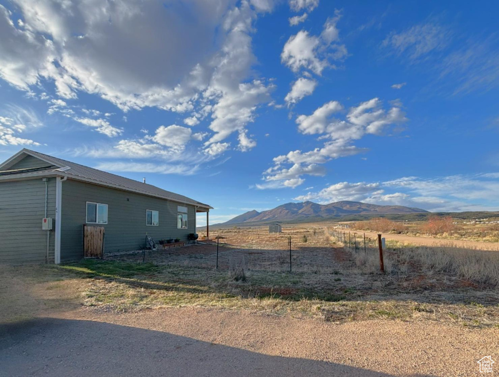 View of yard featuring fence, a rural view, and a mountain view