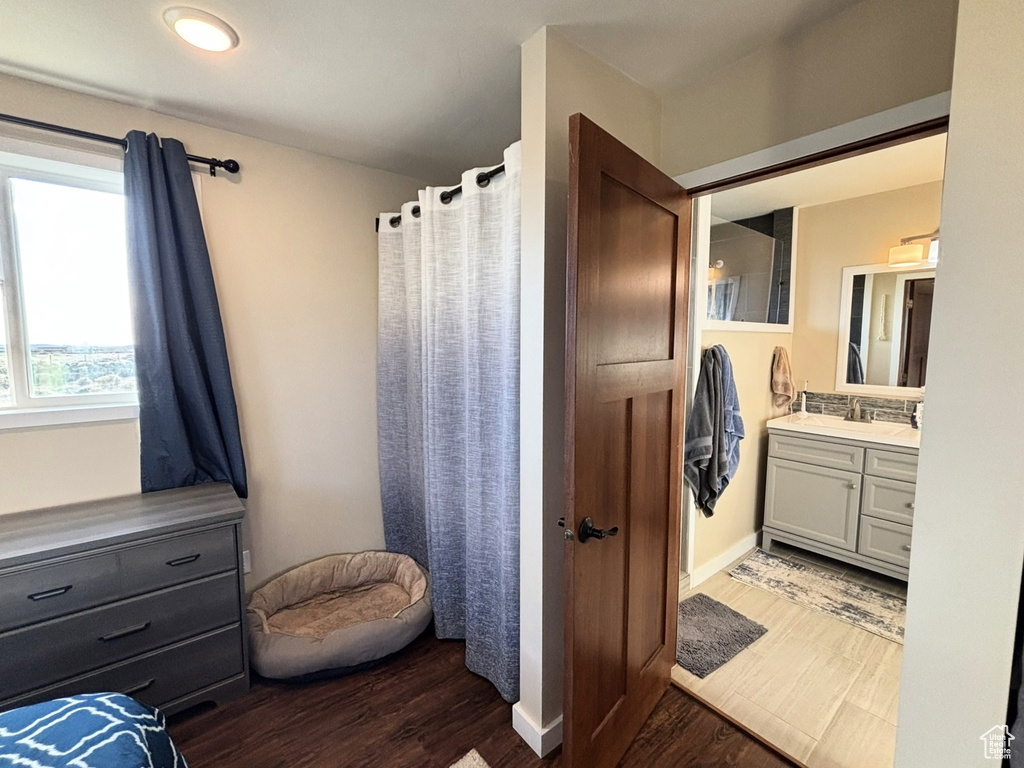 Bathroom featuring curtained shower, vanity, and wood finished floors