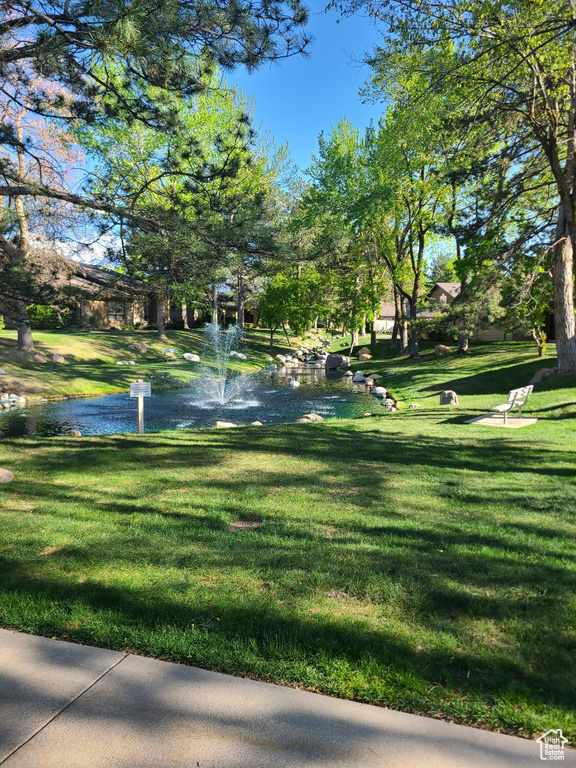 View of property's community with a yard and a water view